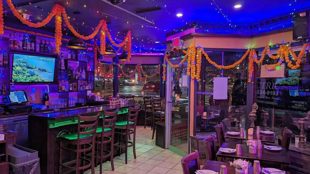 The bar, marigold garlands strung above the rail