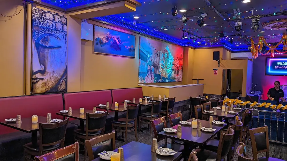 Booths at the front of the room beneath a painted Buddha