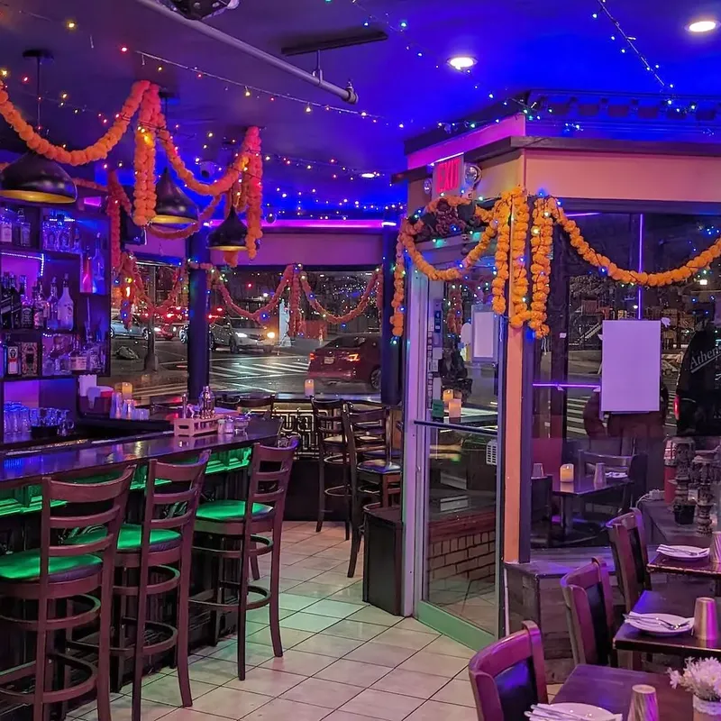 The bar, marigold garlands strung above the rail