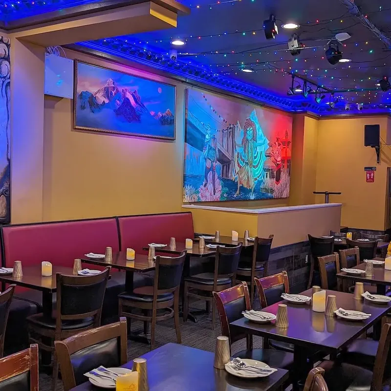 Booths at the front of the room beneath a painted Buddha