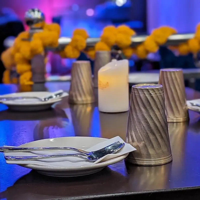 A laid table — plates, a candle, marigolds behind